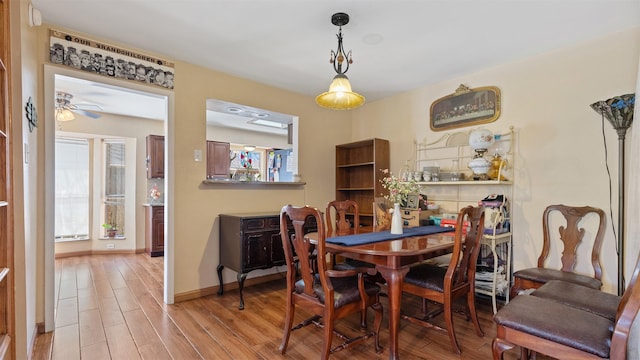 dining space with wood finished floors, baseboards, and ceiling fan