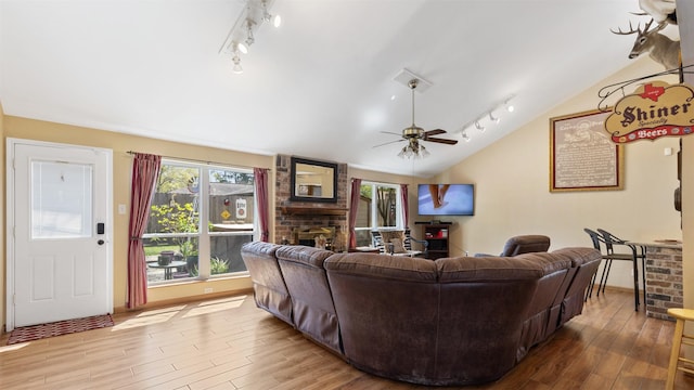 living room featuring a fireplace, a ceiling fan, lofted ceiling, and wood finished floors