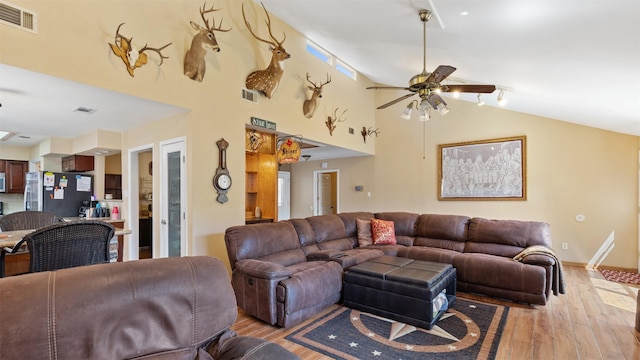 living room featuring visible vents, light wood-style floors, and ceiling fan