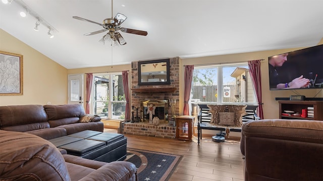 living area featuring a wealth of natural light, wood finished floors, a ceiling fan, and vaulted ceiling