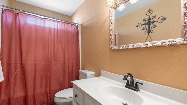 bathroom featuring vanity, a shower with shower curtain, toilet, and a textured wall