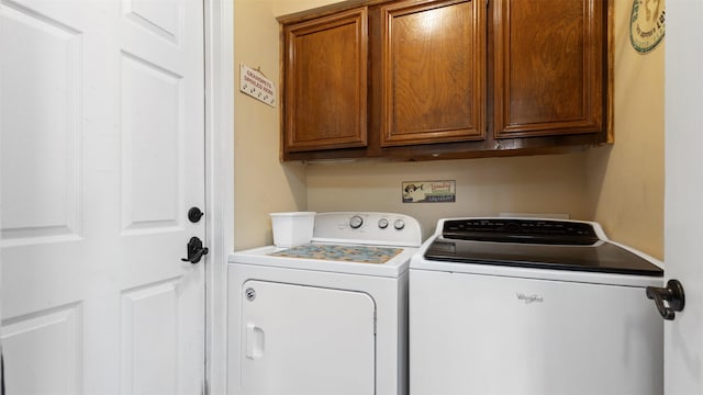 clothes washing area featuring cabinet space and independent washer and dryer