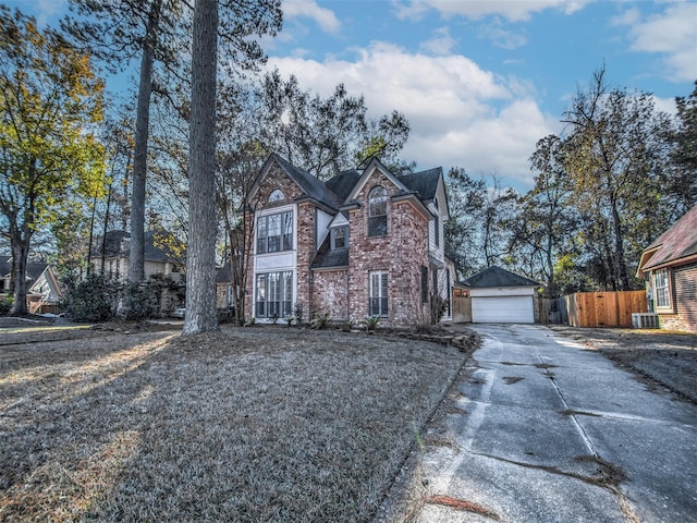 view of front of house with fence, central AC, an outdoor structure, a detached garage, and brick siding