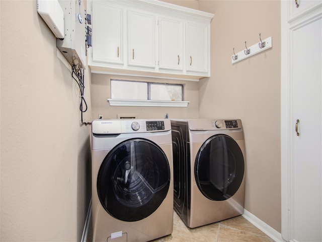 clothes washing area featuring light tile patterned floors, cabinet space, independent washer and dryer, and baseboards