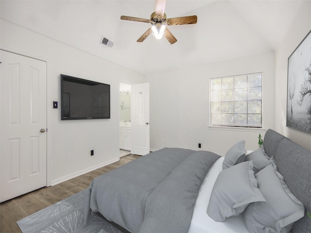 bedroom with a ceiling fan, wood finished floors, visible vents, baseboards, and ensuite bathroom