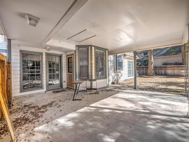 view of patio with an attached carport and fence