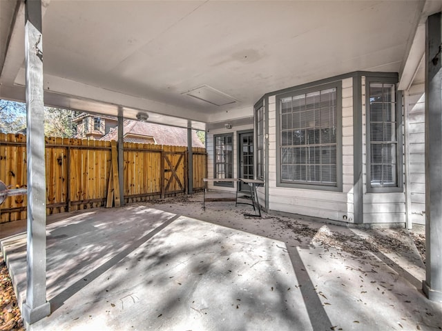 view of patio with an attached carport and fence