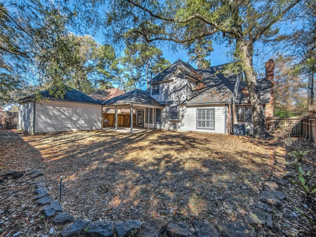 rear view of house with a fenced backyard, a chimney, and a patio area