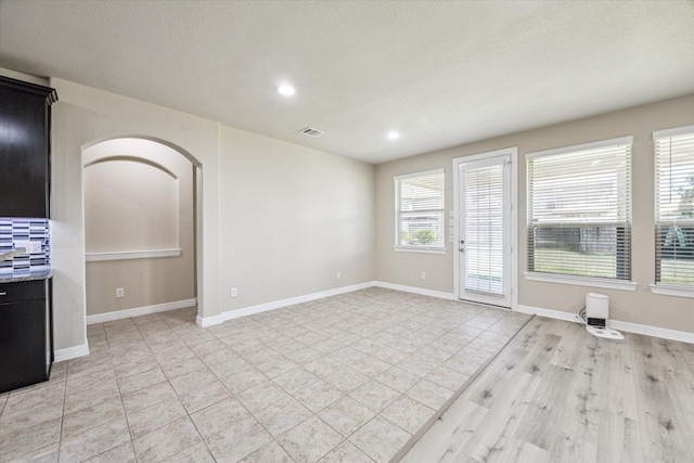 unfurnished living room featuring recessed lighting, visible vents, baseboards, and light tile patterned floors