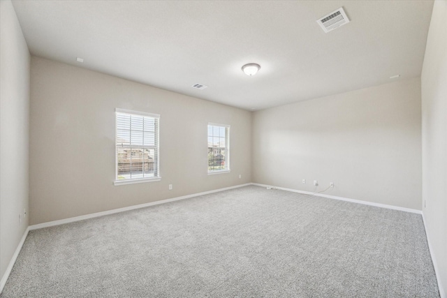 empty room with visible vents, baseboards, and carpet