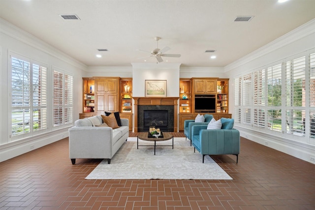 living area with visible vents, ceiling fan, crown molding, and brick floor