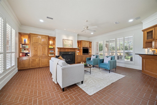 living room featuring brick floor, visible vents, a glass covered fireplace, and recessed lighting