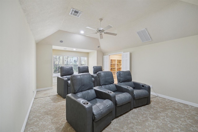 cinema featuring visible vents, light carpet, lofted ceiling, and ceiling fan