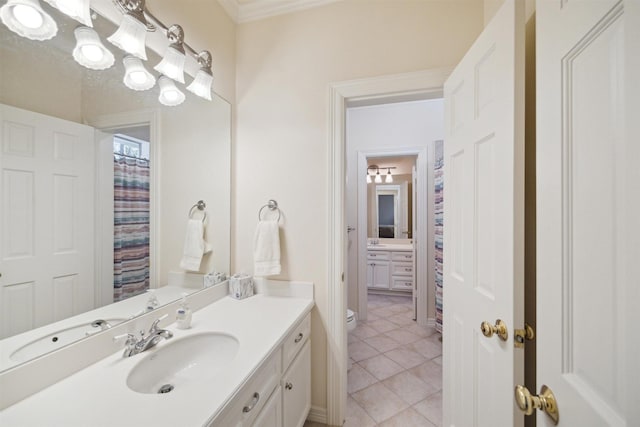 bathroom with baseboards, toilet, vanity, and tile patterned flooring