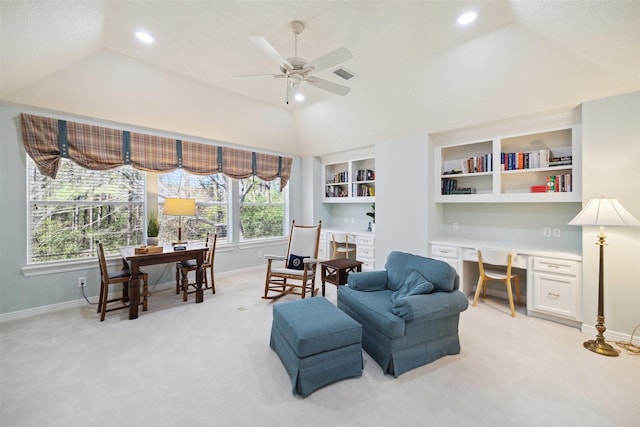 sitting room featuring visible vents, light carpet, built in study area, ceiling fan, and vaulted ceiling