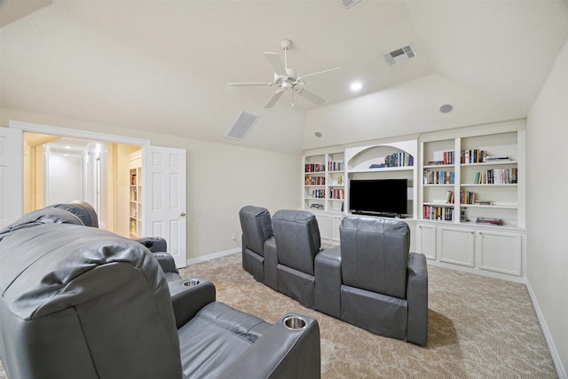 cinema room featuring lofted ceiling, light colored carpet, visible vents, and ceiling fan