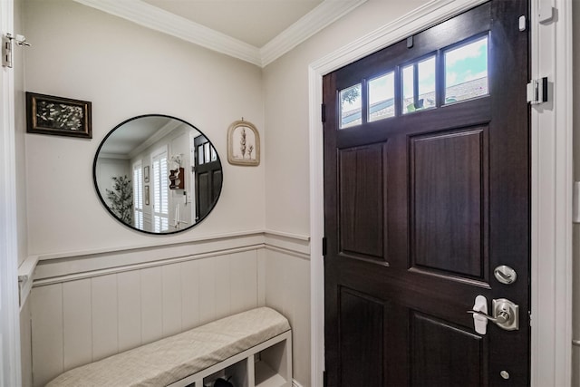 entryway featuring a wainscoted wall and ornamental molding