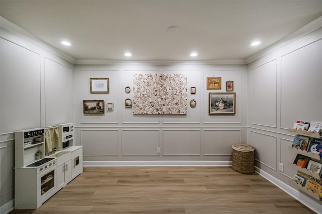 recreation room with a decorative wall, recessed lighting, and light wood finished floors