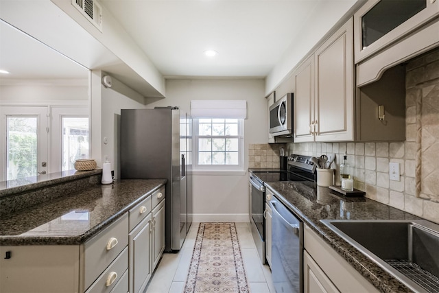 kitchen with visible vents, baseboards, light tile patterned floors, decorative backsplash, and stainless steel appliances