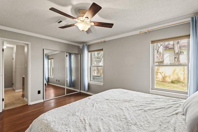 bedroom with baseboards, multiple windows, dark wood-type flooring, and ornamental molding