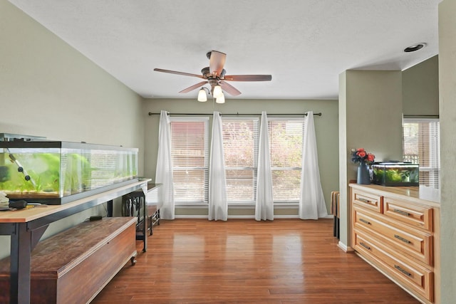 interior space with dark wood finished floors, baseboards, and ceiling fan