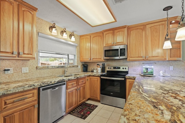 kitchen with light tile patterned floors, backsplash, appliances with stainless steel finishes, and light stone counters