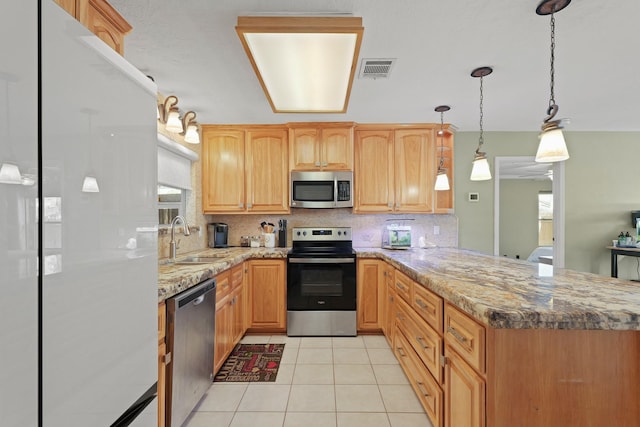 kitchen featuring visible vents, light tile patterned floors, a peninsula, stainless steel appliances, and a sink