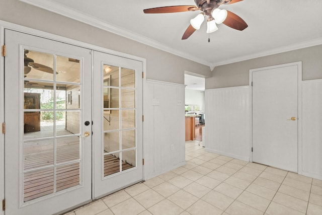 entryway featuring a ceiling fan, french doors, light tile patterned flooring, wainscoting, and crown molding