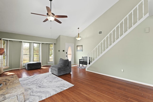 living room with stairway, baseboards, a ceiling fan, and wood finished floors