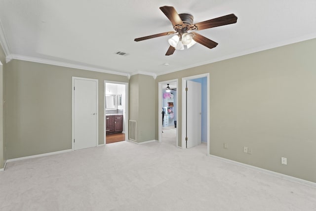 unfurnished bedroom with light carpet, visible vents, a walk in closet, and ornamental molding