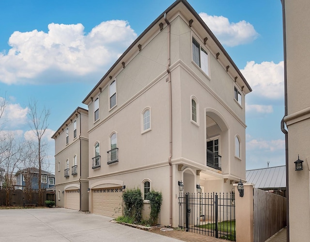 view of property with driveway, a garage, and a fenced front yard