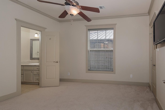 unfurnished bedroom featuring visible vents, light carpet, ornamental molding, ensuite bathroom, and baseboards