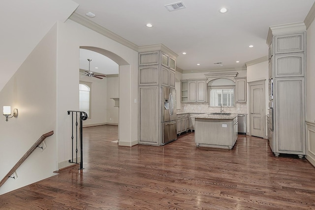 kitchen featuring visible vents, a center island, dark wood-type flooring, and ceiling fan