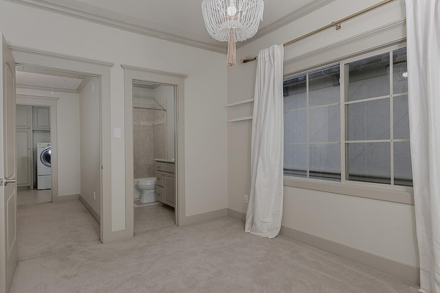 unfurnished bedroom with washer / dryer, attic access, light colored carpet, and ornamental molding