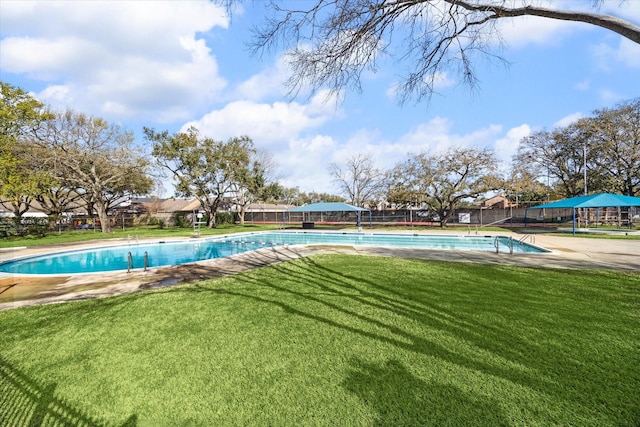 view of pool with a diving board, a yard, a fenced in pool, and fence