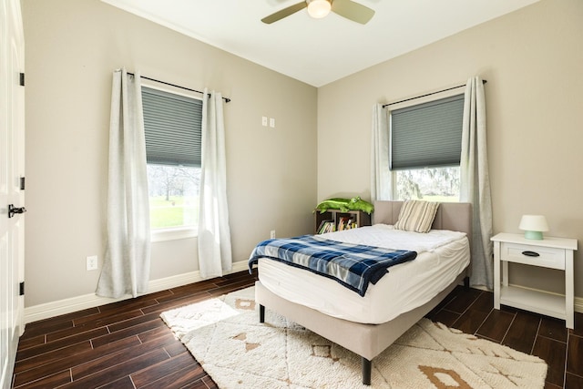 bedroom with ceiling fan, baseboards, and wood finish floors