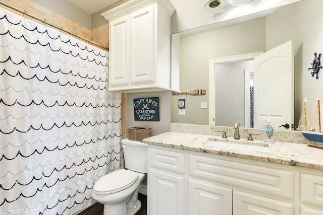 bathroom with vanity, curtained shower, and toilet