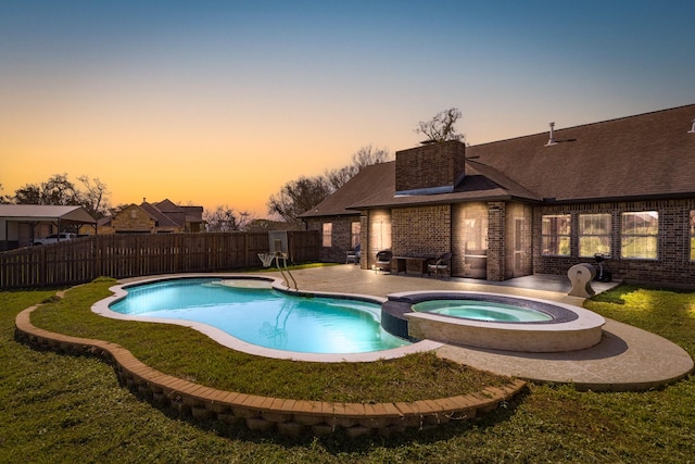 view of pool featuring a patio, a pool with connected hot tub, and a fenced backyard