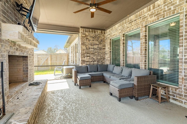 view of patio featuring a ceiling fan, an outdoor living space with a fireplace, and fence