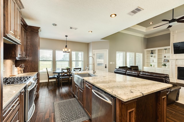 kitchen with visible vents, a sink, dark wood-type flooring, appliances with stainless steel finishes, and open floor plan