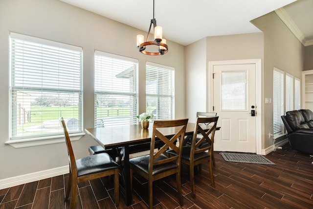 dining space with baseboards, an inviting chandelier, wood tiled floor, and crown molding