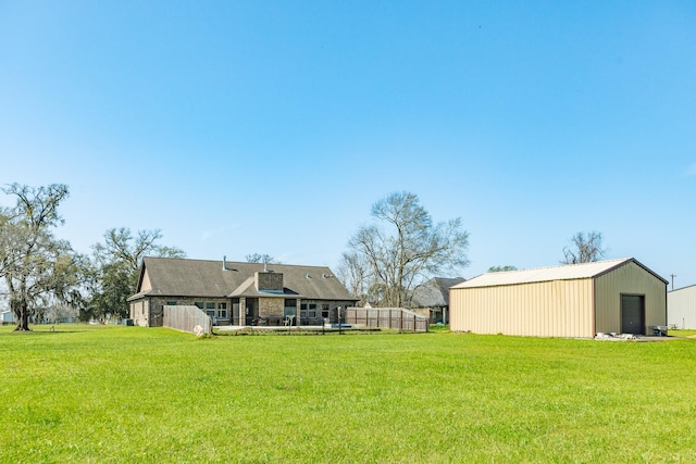 view of yard with an outbuilding, an outdoor structure, and fence