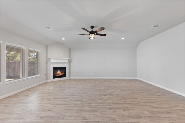 unfurnished living room featuring vaulted ceiling, light wood-style floors, visible vents, and ceiling fan