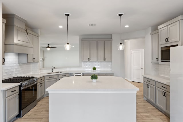 kitchen featuring visible vents, a sink, gray cabinetry, ceiling fan, and stainless steel appliances