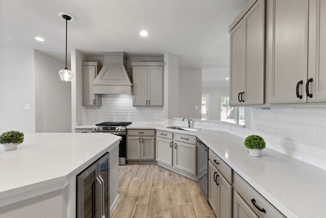 kitchen with stainless steel gas range oven, custom range hood, a sink, wine cooler, and dishwashing machine