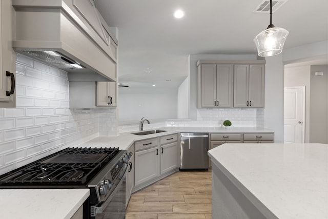 kitchen with visible vents, premium range hood, black gas range, dishwasher, and a sink