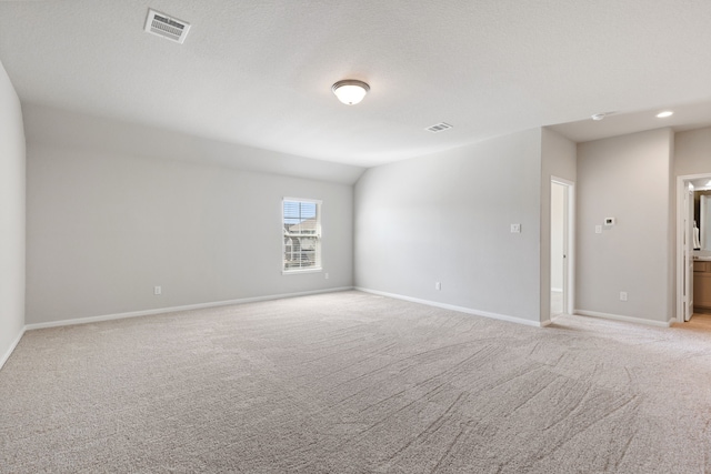 empty room with baseboards, visible vents, and light carpet