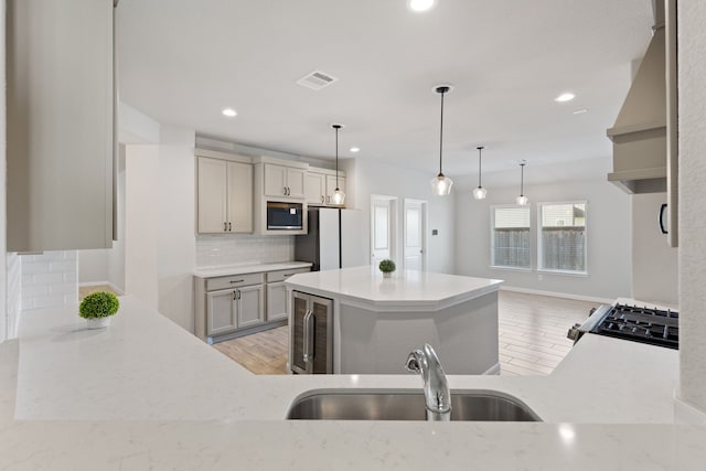 kitchen featuring recessed lighting, a sink, gas range, stainless steel microwave, and backsplash