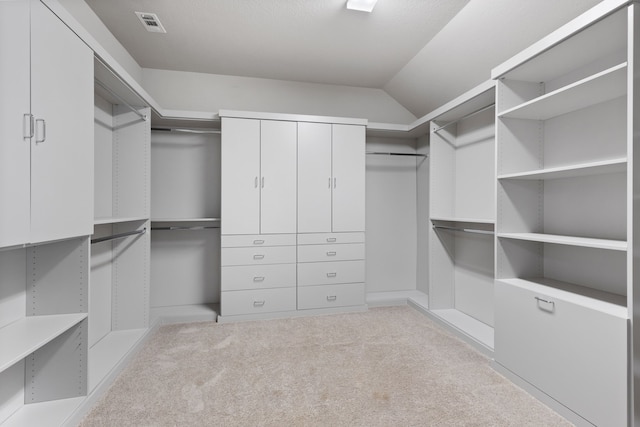 spacious closet featuring vaulted ceiling and carpet floors