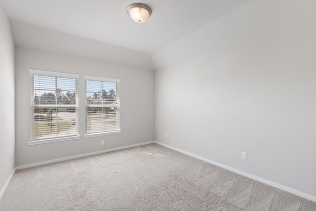 unfurnished room featuring lofted ceiling, baseboards, and carpet floors